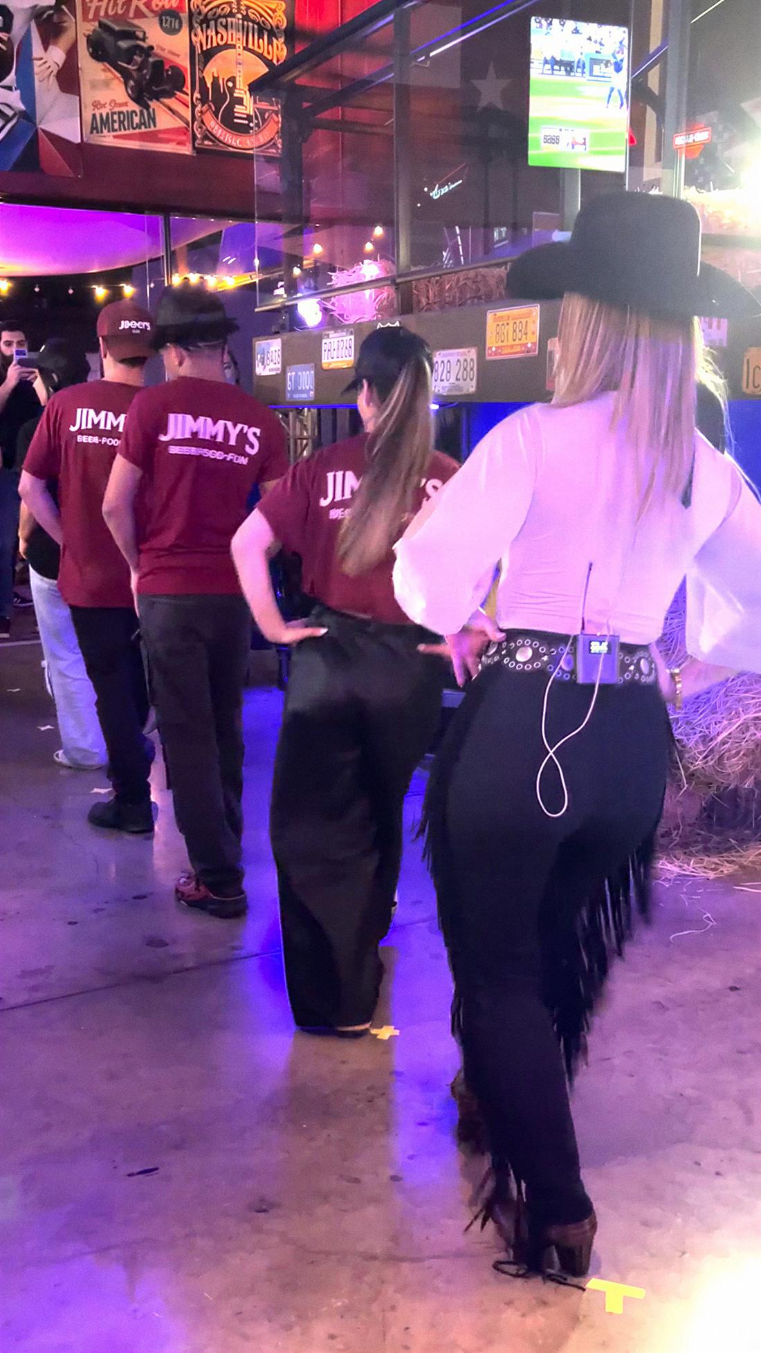Dançarinas da Black Horse Line Dance de chapéu e franjas puxando a coreografia na pista